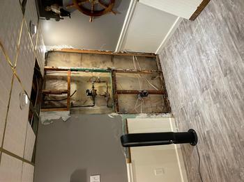 Basement wall with exposed plumbing and wiring