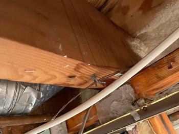 Close-up of water damage on a wooden beam in the ceiling