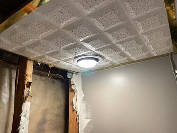 Ceiling corner showing water damage and exposed insulation